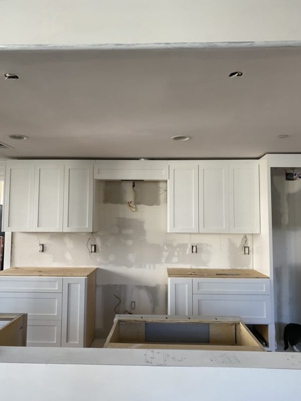A modern kitchen featuring white cabinets and countertops