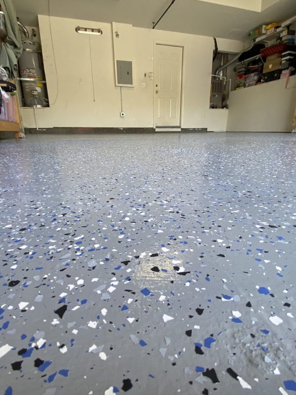 A garage floor featuring a blue and white speckled paint design